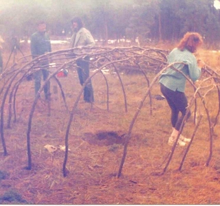 people connecting the poles of the sweat lodge