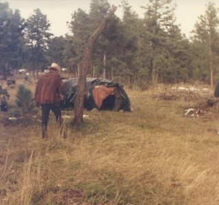 a couple of people  standing near the sweat lodge