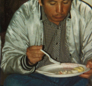 Joe W. Azure eating a plate of food at Memorial Feed ceremony for ancestors 