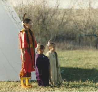 woman standing with two children