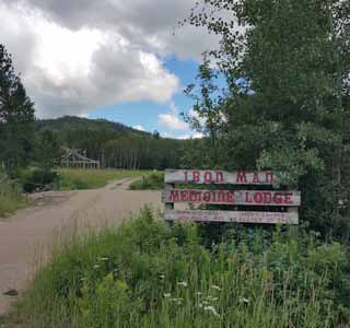  View from the road with a sign for Iron Man Medicine Lodge